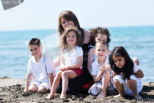 Image of group portrait of childrens with teacher on beach