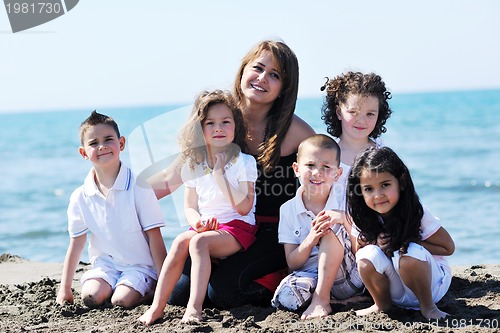 Image of group portrait of childrens with teacher on beach