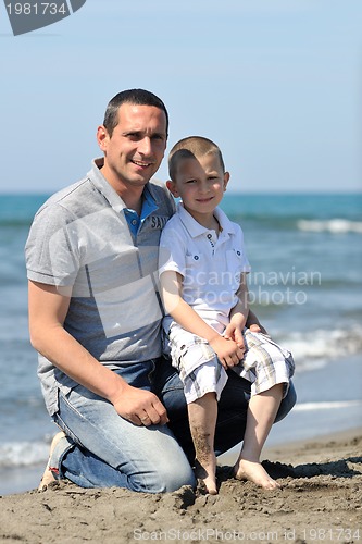 Image of happy father and son have fun and enjoy time on beach