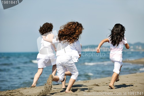 Image of happy child group playing  on beach