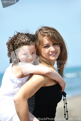 Image of group portrait of childrens with teacher on beach