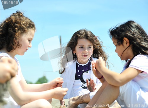 Image of happy child group playing  on beach