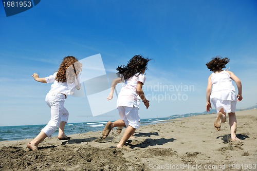 Image of happy child group playing  on beach