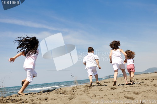 Image of happy child group playing  on beach