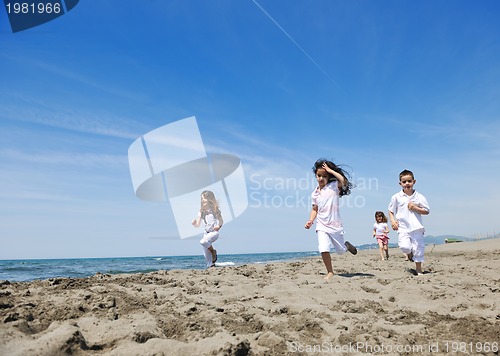 Image of happy child group playing  on beach