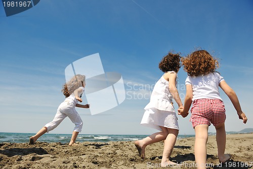 Image of happy child group playing  on beach