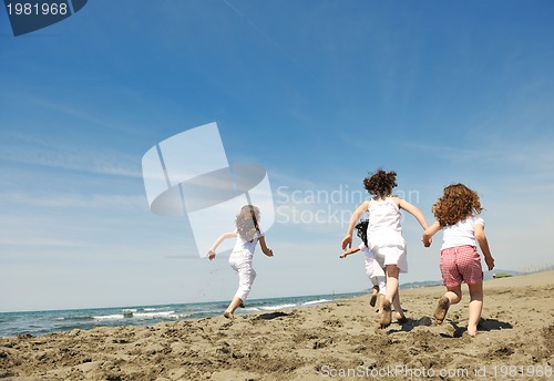 Image of happy child group playing  on beach