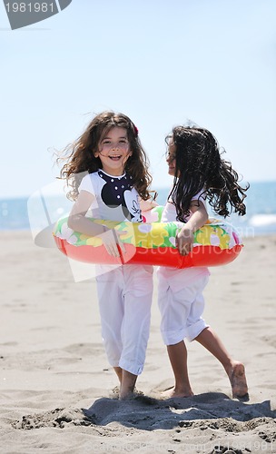 Image of happy child group playing  on beach