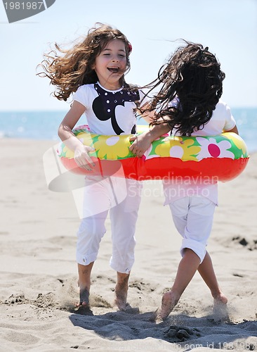 Image of happy child group playing  on beach