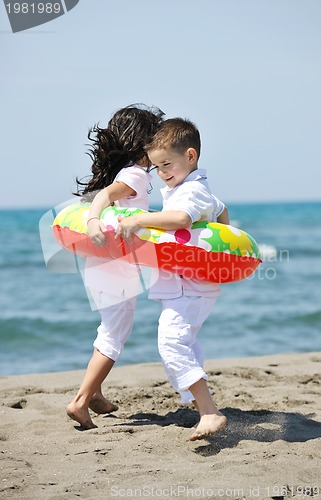Image of happy child group playing  on beach