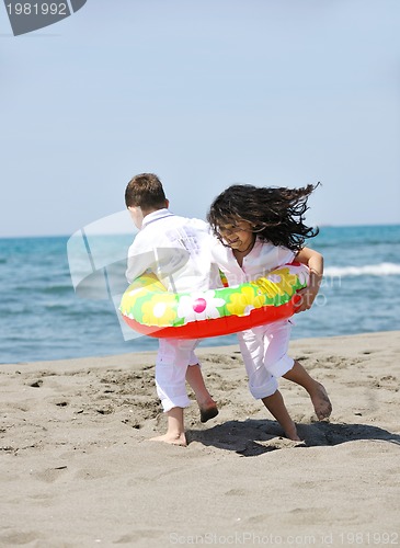 Image of happy child group playing  on beach