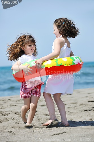 Image of happy child group playing  on beach