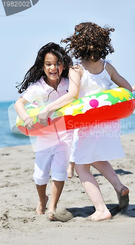 Image of happy child group playing  on beach
