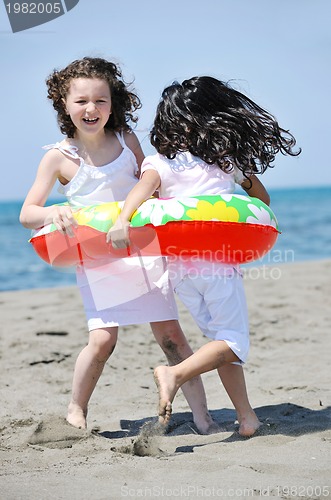 Image of happy child group playing  on beach