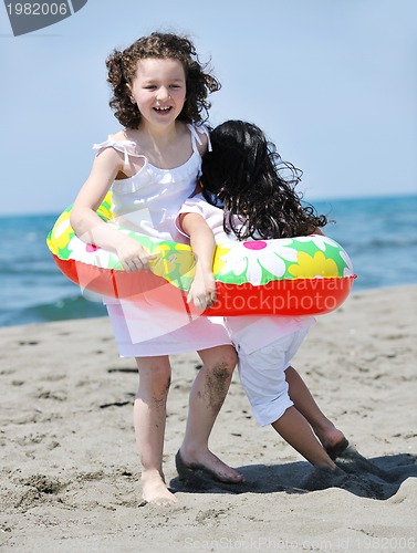Image of happy child group playing  on beach
