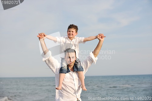 Image of happy father and son have fun and enjoy time on beach