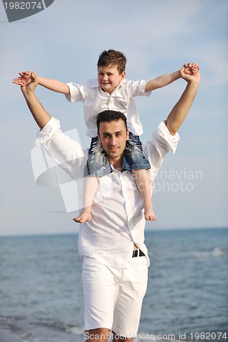 Image of happy father and son have fun and enjoy time on beach