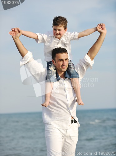 Image of happy father and son have fun and enjoy time on beach