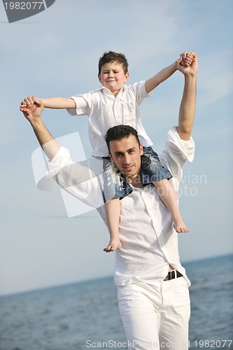 Image of happy father and son have fun and enjoy time on beach