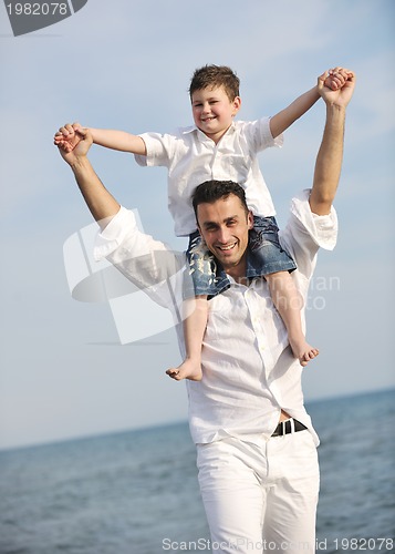 Image of happy father and son have fun and enjoy time on beach