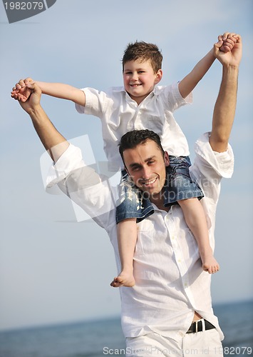 Image of happy father and son have fun and enjoy time on beach