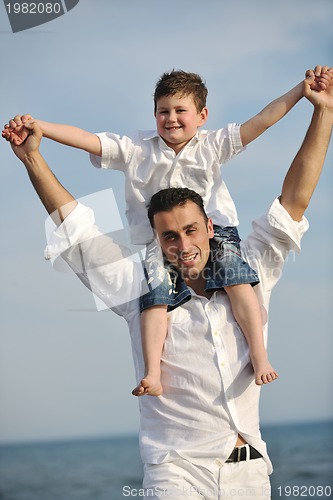 Image of happy father and son have fun and enjoy time on beach