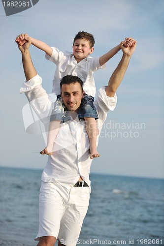 Image of happy father and son have fun and enjoy time on beach