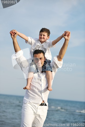 Image of happy father and son have fun and enjoy time on beach