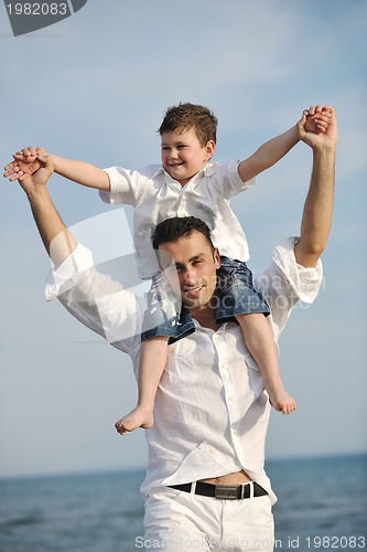 Image of happy father and son have fun and enjoy time on beach
