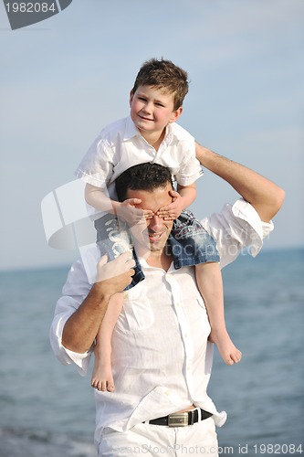 Image of happy father and son have fun and enjoy time on beach