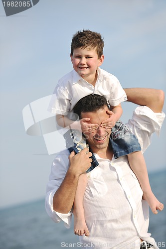 Image of happy father and son have fun and enjoy time on beach