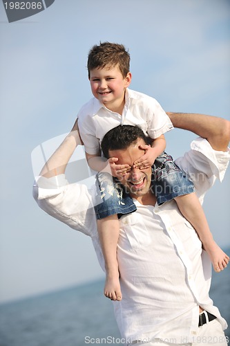 Image of happy father and son have fun and enjoy time on beach