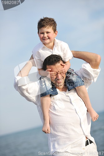 Image of happy father and son have fun and enjoy time on beach