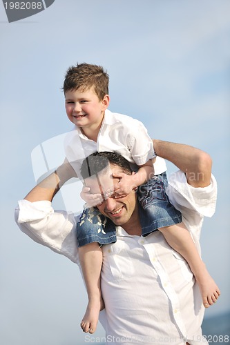 Image of happy father and son have fun and enjoy time on beach