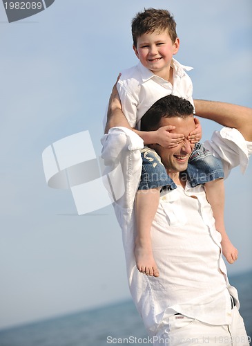 Image of happy father and son have fun and enjoy time on beach