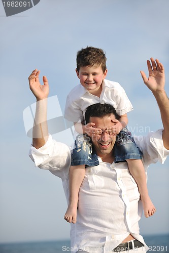 Image of happy father and son have fun and enjoy time on beach