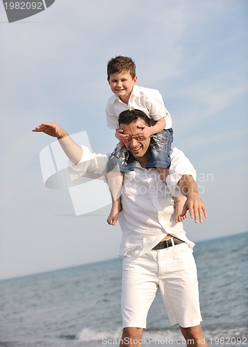 Image of happy father and son have fun and enjoy time on beach