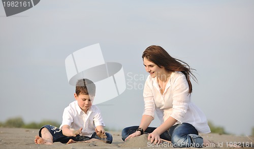 Image of mom and son relaxing on beach