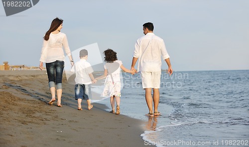 Image of happy young family have fun on beach at sunset