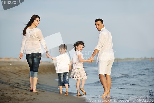 Image of happy young family have fun on beach at sunset