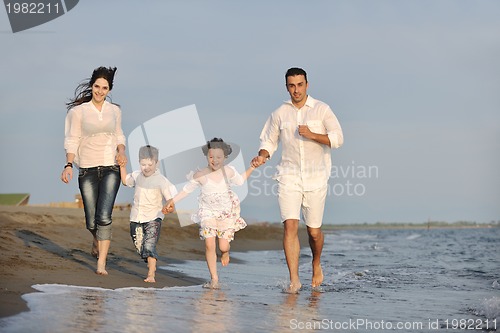 Image of happy young family have fun on beach at sunset