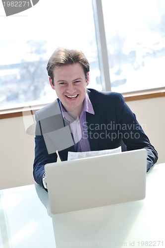 Image of young business man alone in conference room