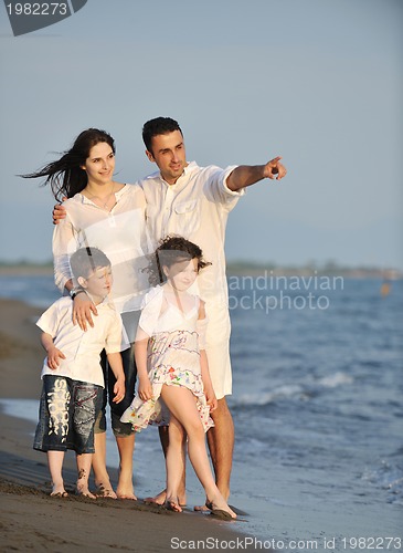 Image of happy young family have fun on beach at sunset