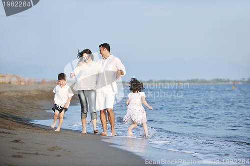 Image of happy young family have fun on beach at sunset
