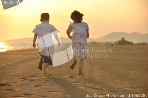 Image of happy young family have fun on beach at sunset