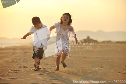 Image of happy young family have fun on beach at sunset