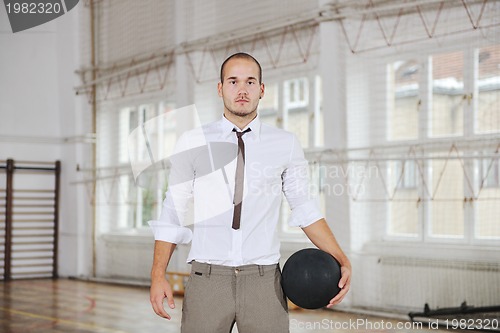 Image of businessman holding basketball ball