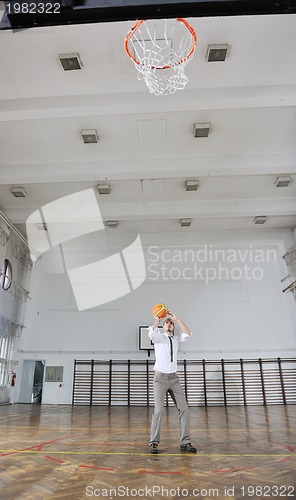 Image of businessman holding basketball ball