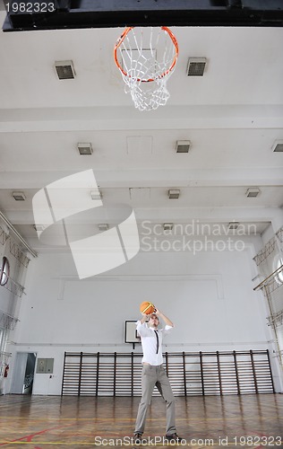 Image of businessman holding basketball ball