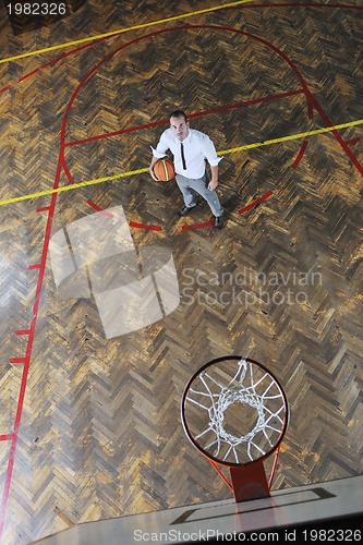 Image of businessman holding basketball ball